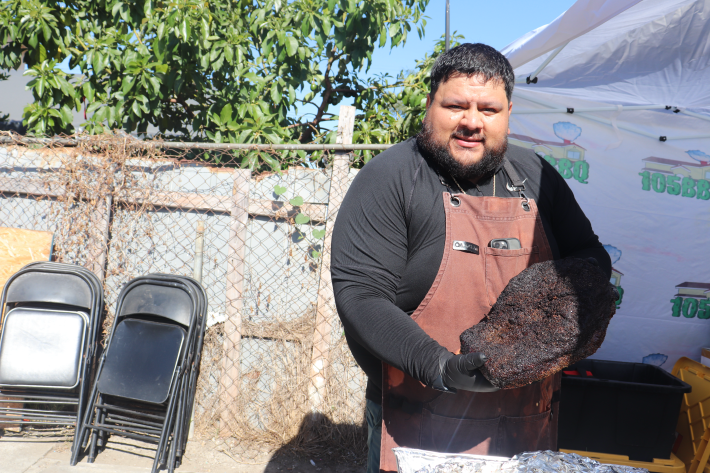 a man holds a smoked brisket