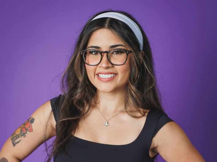a woman with a headband and glasses smiling