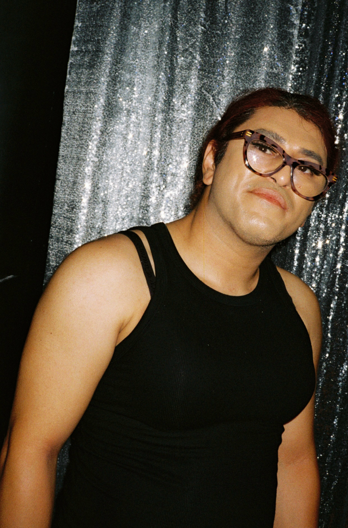 a person with glasses and a black tank top
