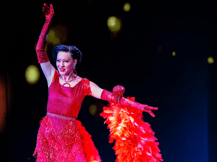 a woman in a red dress with a matching feather boa