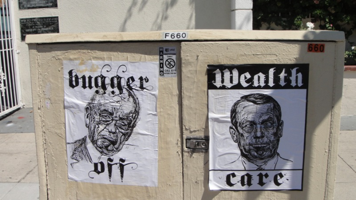 Posters of Rupert Murdoch and John Boehner that say "bugger off" and "wealthcare"
