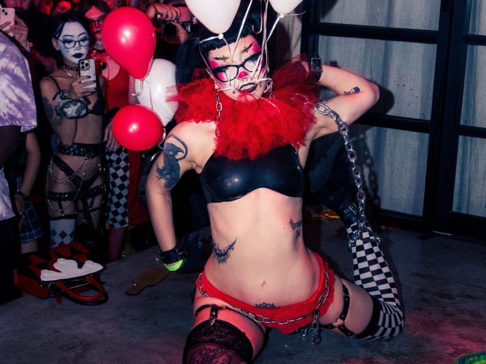 a woman dressed in lingerie and clown makeup
