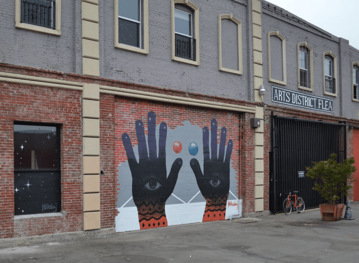 a mural of hands on a brick wall