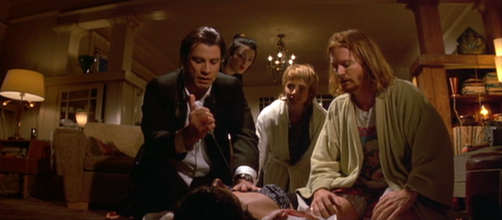 Vincent (John Travolta) prepares to inject Mia (Uma Thurman) with an adrenaline shot as Lance (Eric Stoltz), Jody (Rosanna Arquette), and Trudi (Bronagh Gallagher) look on