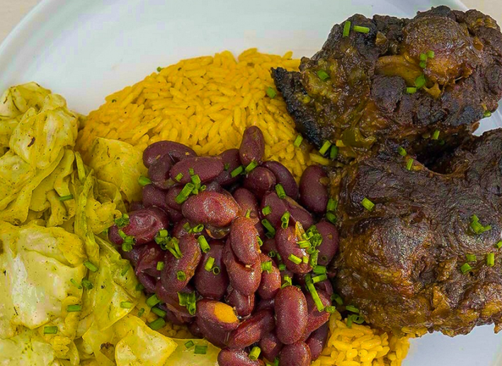 Oxtails, red beans on Spanish rice, and cabbage in close-up