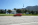 a car driving down a road in front of a cemetery