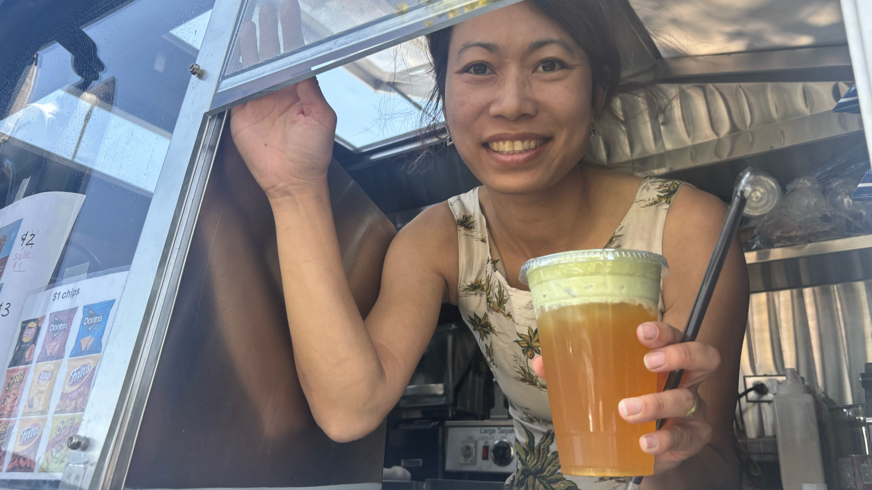 a woman holds a drink out