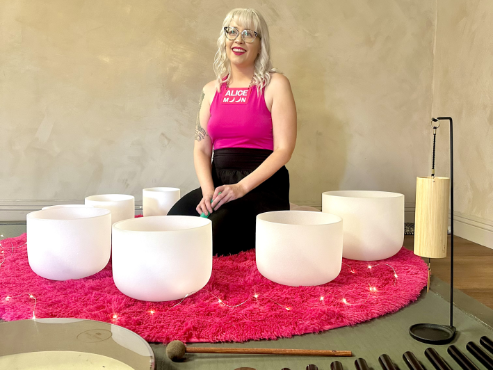 a woman surrounded by sound bowls