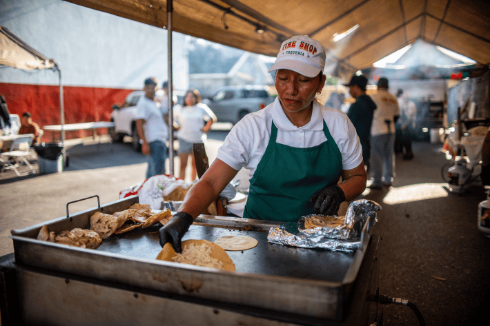 a staff member preps a taco order