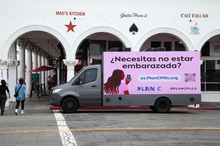 a billboard in Spanish for abortion pills attached to a truck