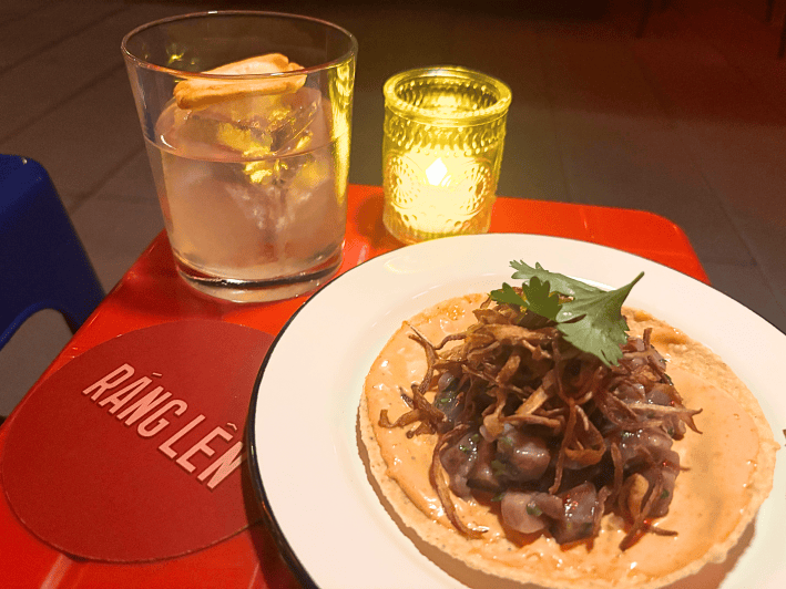 a drink in a glass next to a tuna tostada