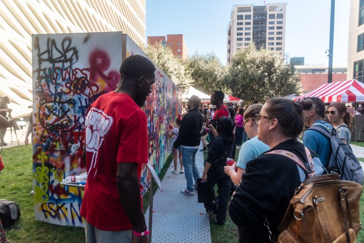 people at an outdoor live graffiti event