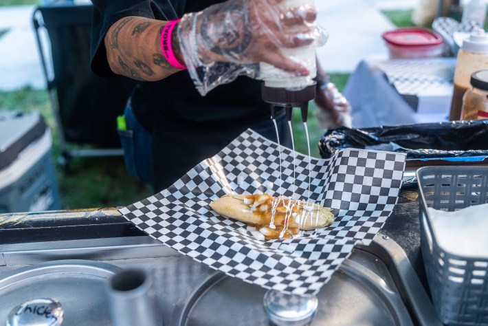 a woman adds crema to a tamal