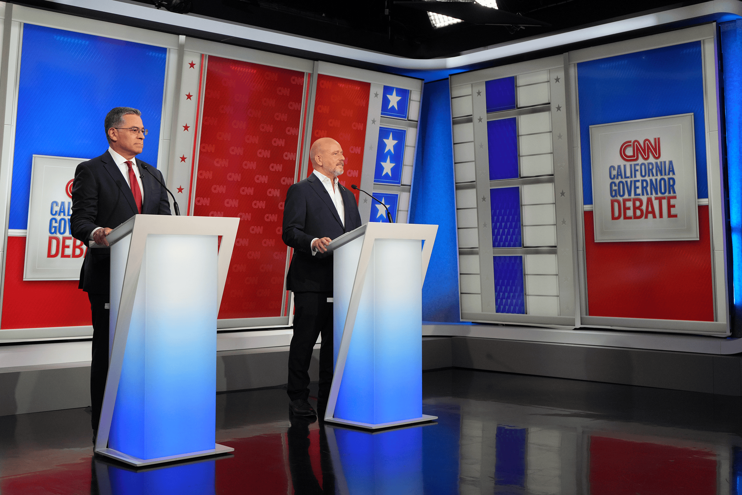 two men behind podiums on a stage