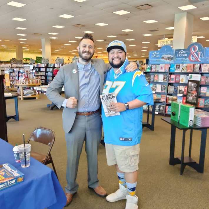 David Romero poses with a fan of his book.