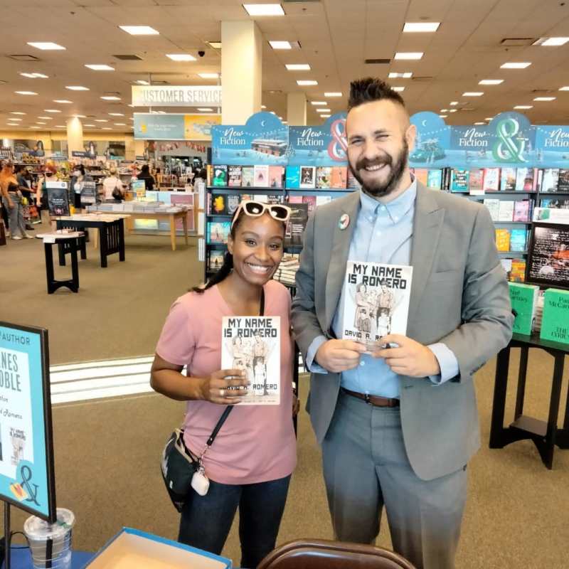 David Romero poses with a fan of his book.
