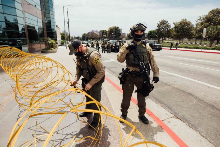 Two LA County Sheriffs set up a barricade.