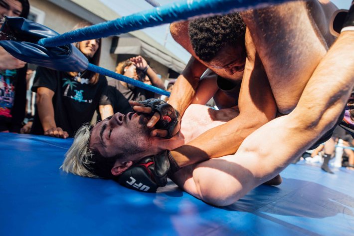 A fighter is pinned on corner of the ring.
