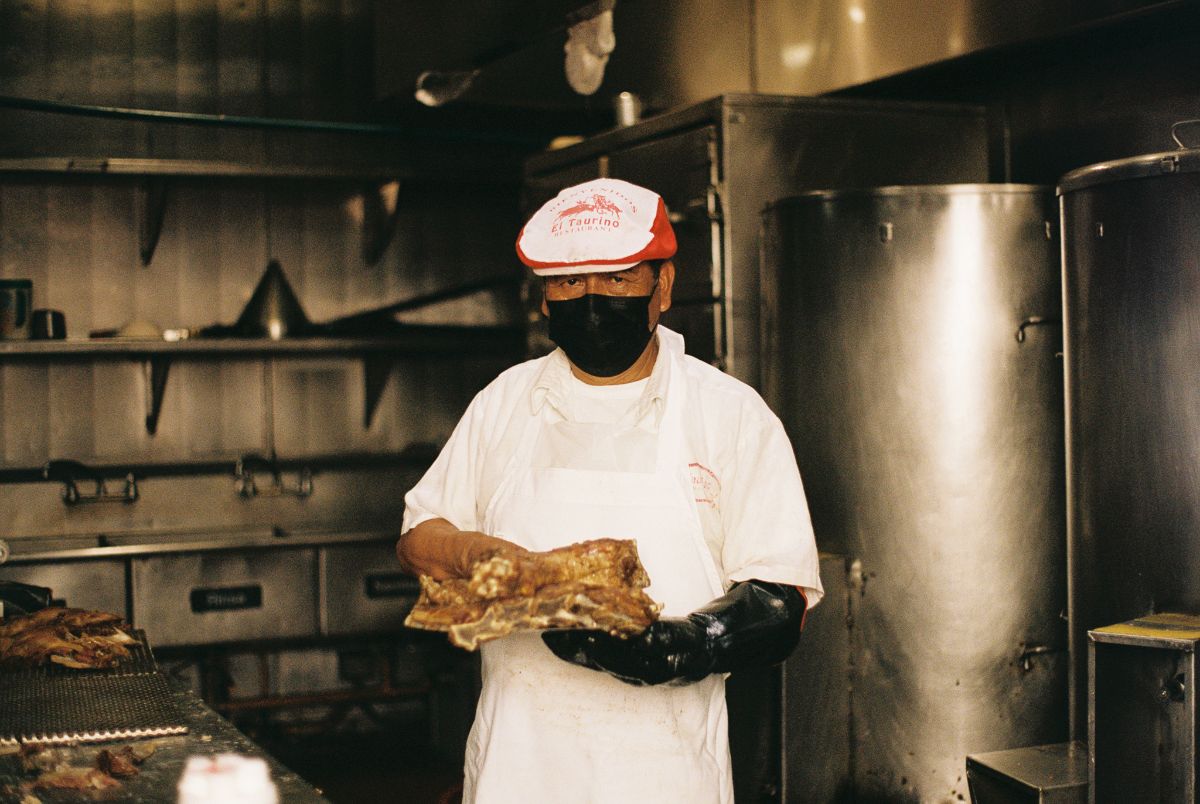 A taquero at El Taurino holding barbacoa meat.