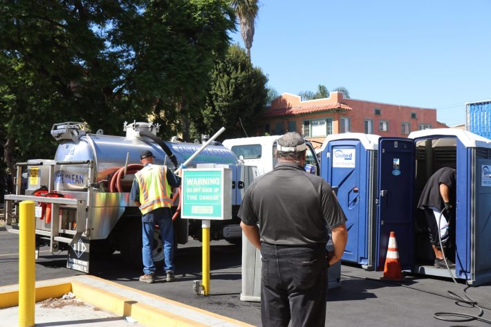 Cleaning porta-potties during vending hours.