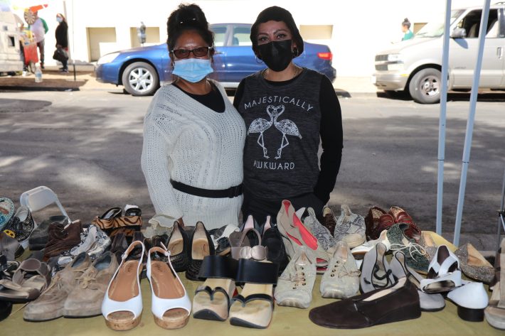 Sandra Escalante and Erika Ruiz both merchandise vendors outside of the LACC swapmeet pose in front of Escalante's stand.