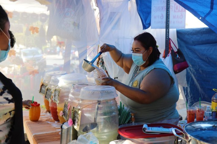 Arely Tafolla Garcia who sells aguas frescas right outside the LACC Swapmeet is one of the vendors who solely relies on her weekend sales to care for her and her family. She vends next to her mother and sister's stand where they sell tacos, pozole, and guisados.