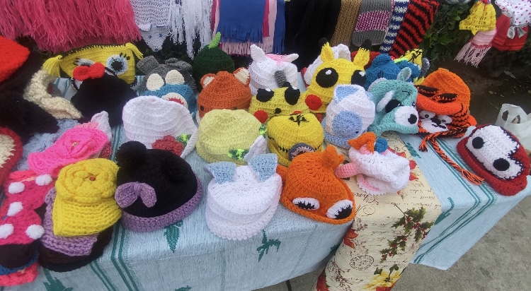 Maria’s knitted hat display. Photo by Nancy Cruz.