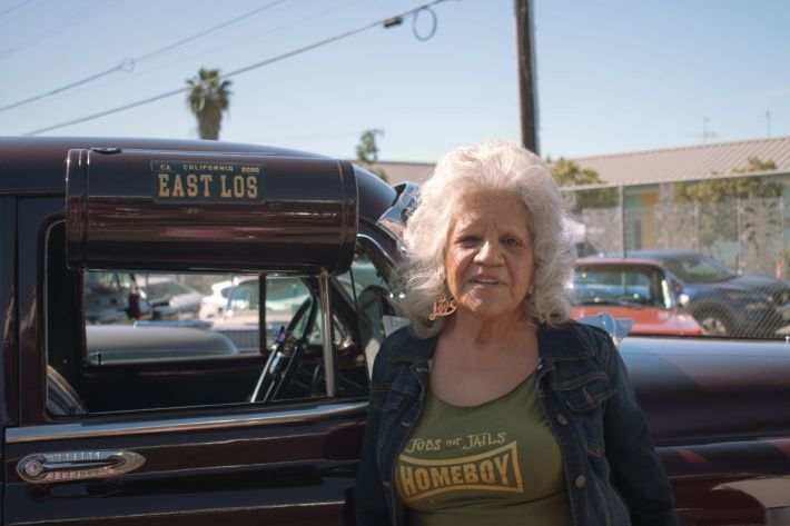 Irene Murrillo Stands by a classic car.