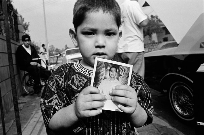 Mike holds a photo of his father, who is in prison. Boyle Heights, Los Angeles CA, 1993