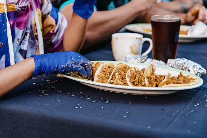 A plate of tacos ready to get eaten really quickly.