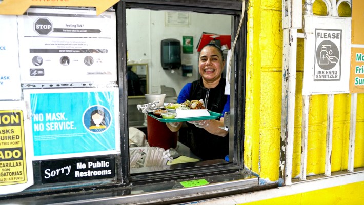 Virginia Ardaya serving a plate of her unique Bolivian-seasoned barbacoa de borrego.