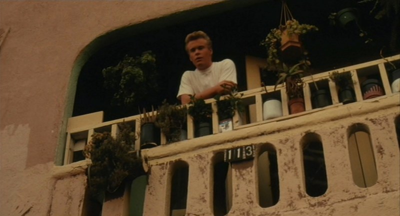 Young J.D. (Steve Wilcox) talks to Santana from his apartment balcony. (Universal Pictures)