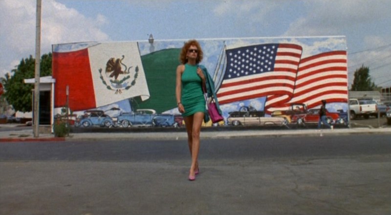 The redheaded girl in a green dress approaches the auto body shop. Photo via Universal Pictures.