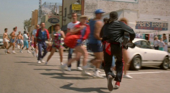 High Top (Glenn Plummer) runs through a crowd in Venice Beach. Screenshot via Orion Pictures.