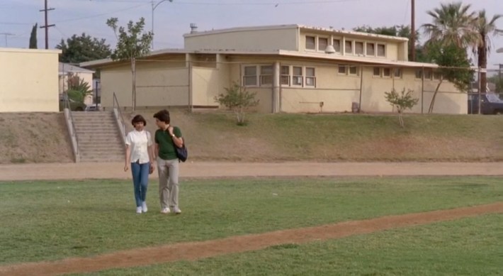 Ana (Vanessa Marquez) and Javier (Patrick Baca) walk on the Garfield athletic field. Photo via Warner Bros. Pictures.