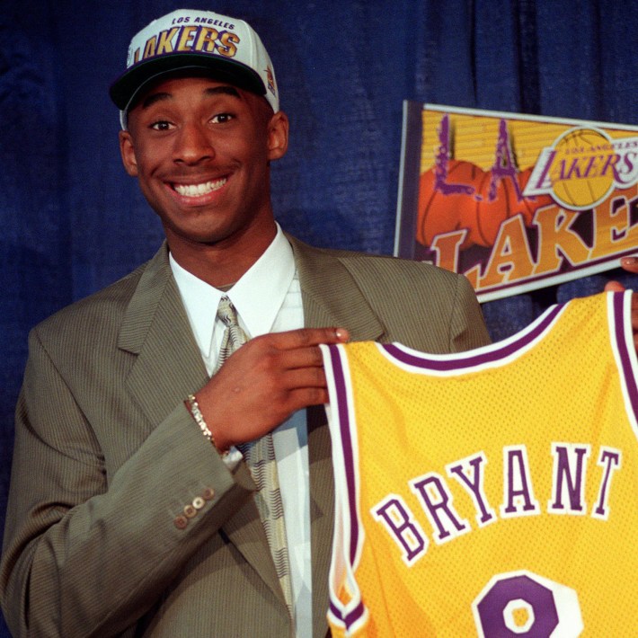 Kobe Bryant, 17, jokes with the media as he holds his Los Angeles Lakers jersey during a news conference Friday, July 12, 1996